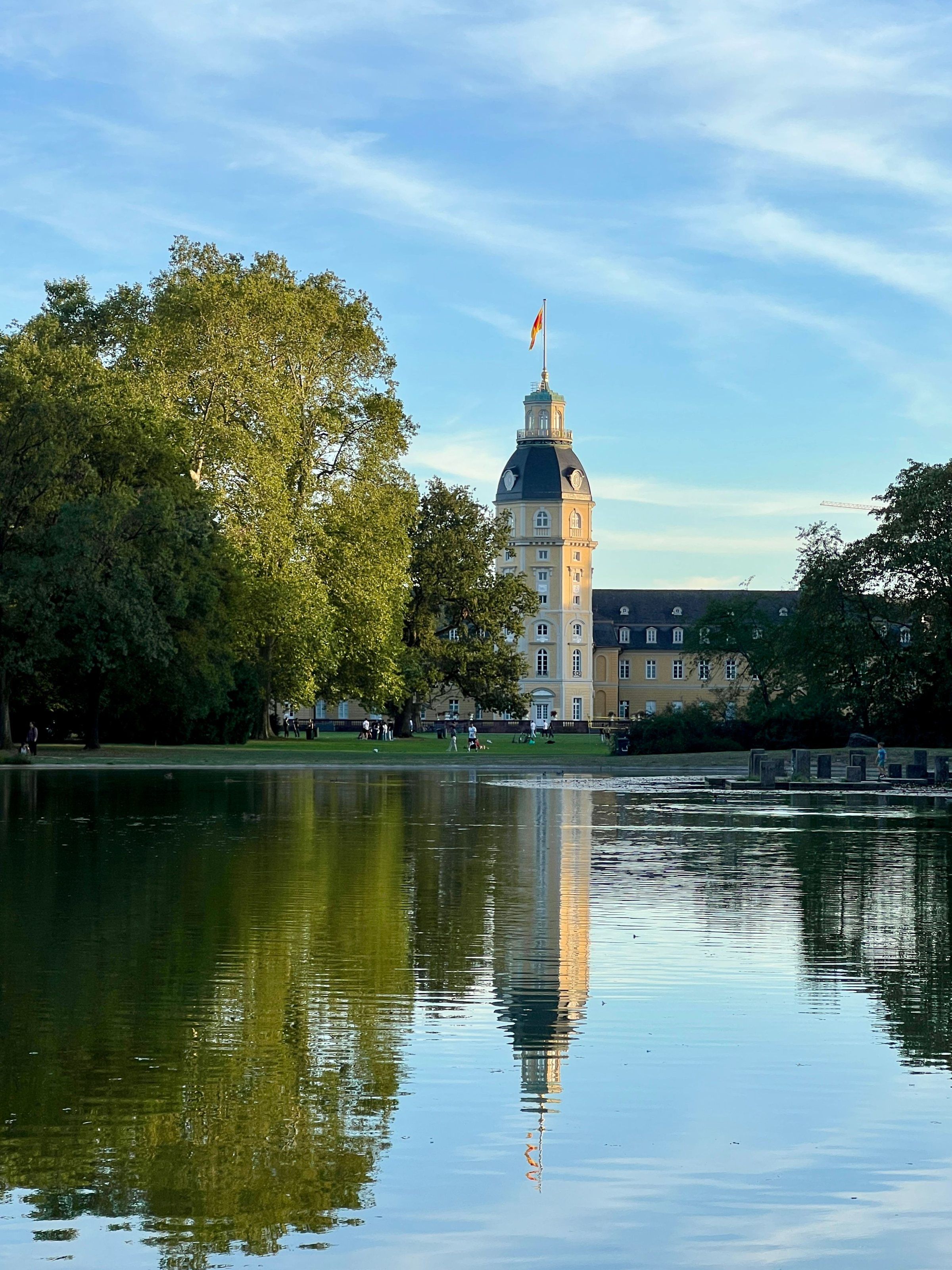 Der Turm des Karlsruher Schlosses spiegelt sich im See des Schlossgartens
